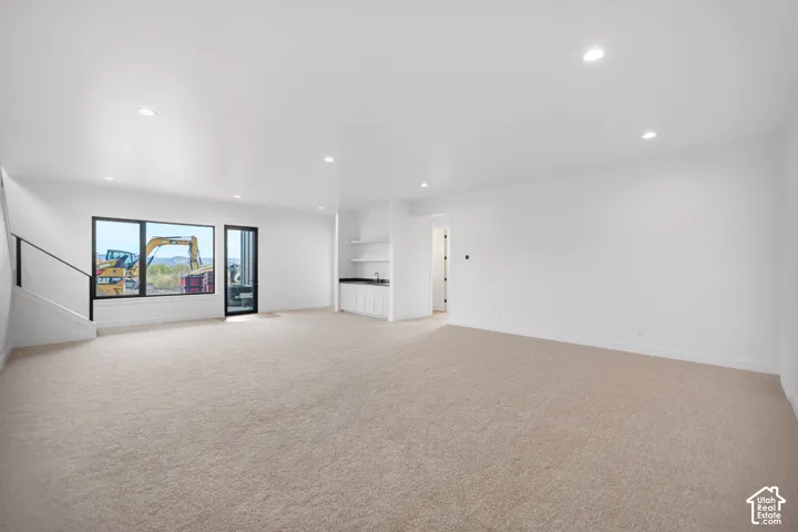 Recessed lighting, large windows, an integrated wet bar, and wall-to-wall carpeting