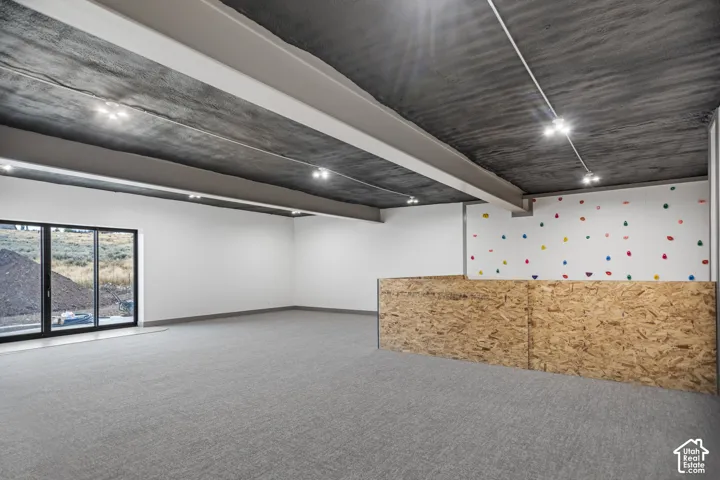 Expansive room with neutral carpeting and white walls
