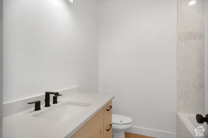 Modern vanity with a light-toned countertop, integrated rectangular sink, and matte black faucet