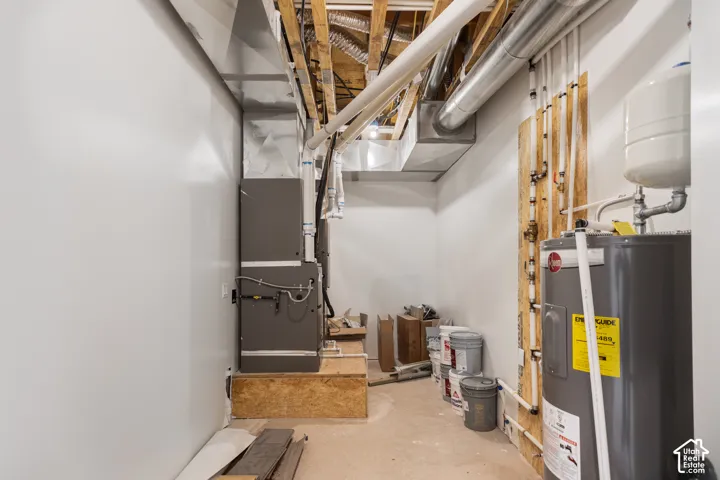 Exposed ceiling joists, visible ductwork, and a water heater
