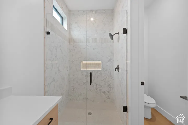 Walk-in shower with full-height tile, a transom window, and a built-in recessed niche with accent lighting