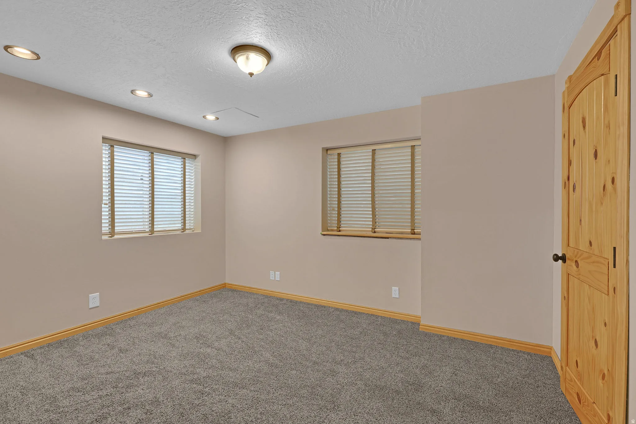 Carpeted empty room featuring a textured ceiling and recessed lighting