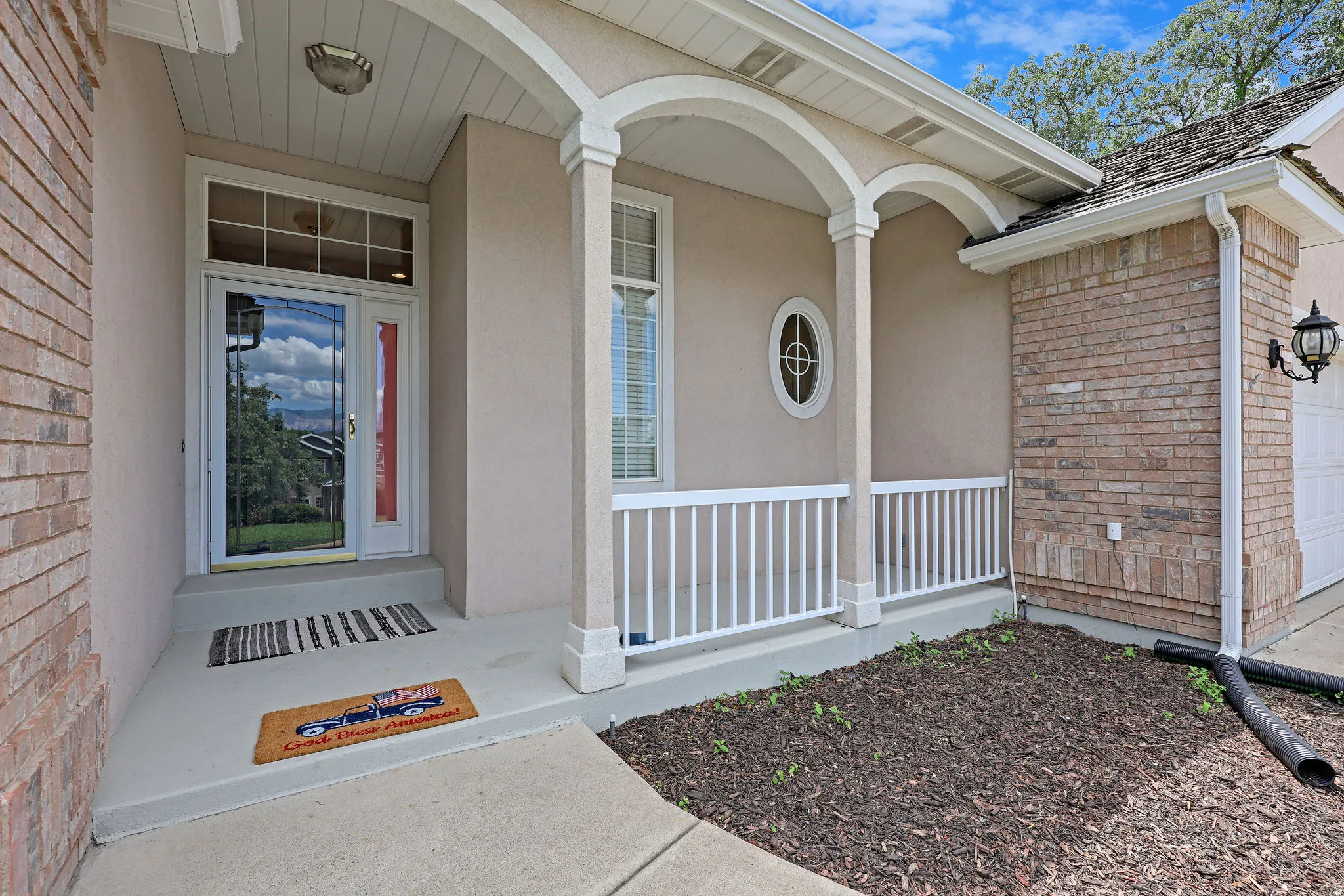 Property entrance featuring brick siding and covered porch