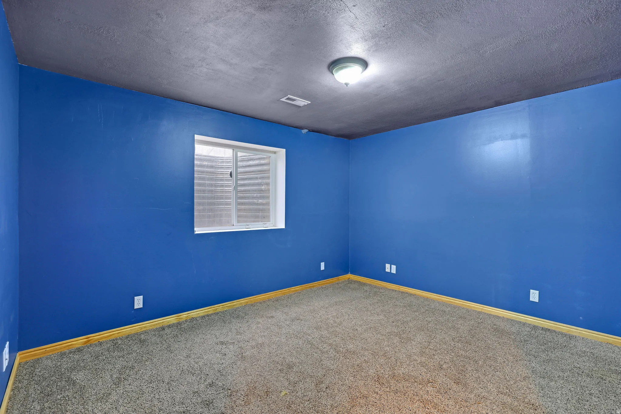Spare room featuring a textured ceiling and carpet floors