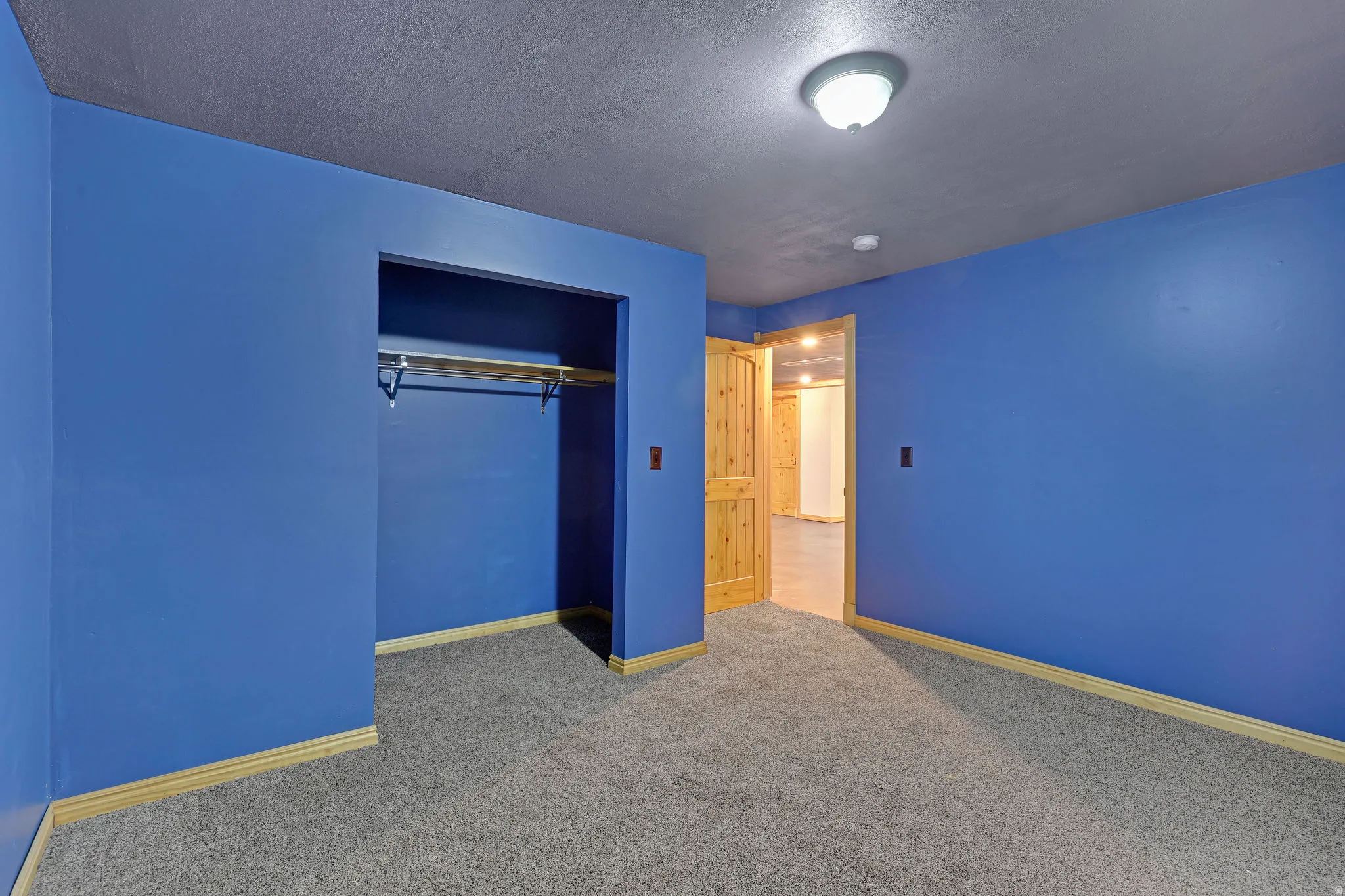 Unfurnished bedroom with a textured ceiling, carpet, and a closet