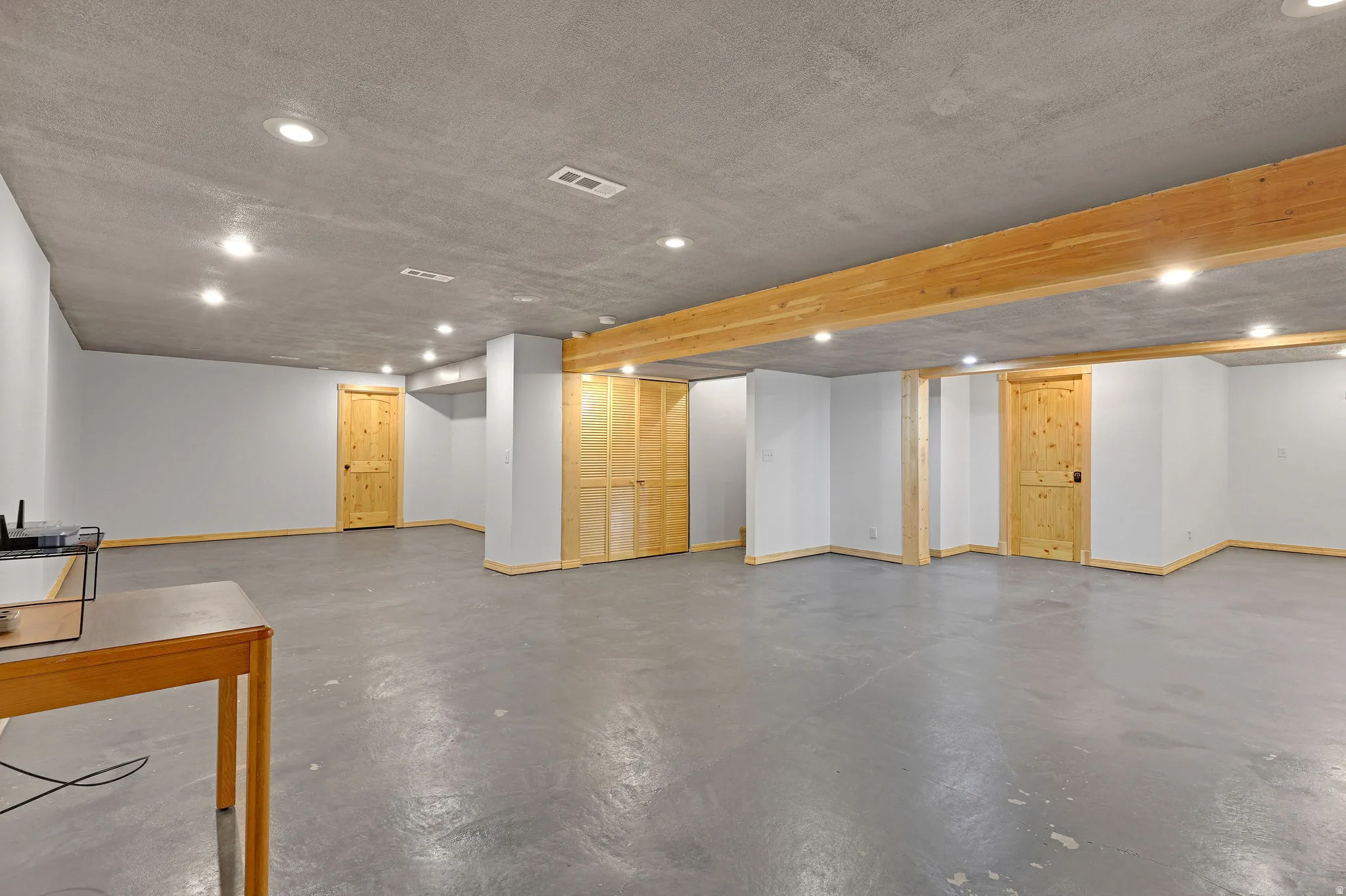 Finished basement with recessed lighting and a textured ceiling