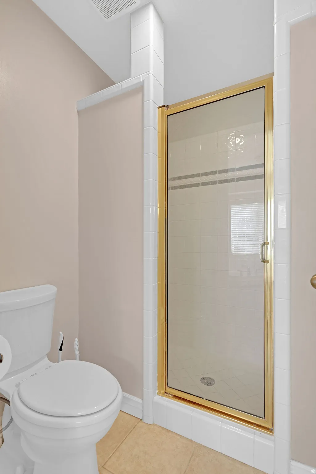 Full bathroom featuring tile patterned floors and a shower stall
