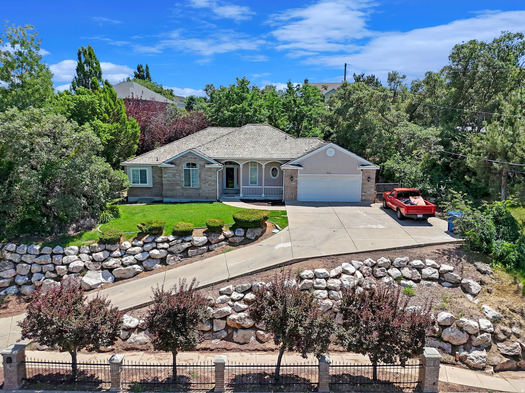 Ranch-style house featuring driveway, covered porch, and a garage