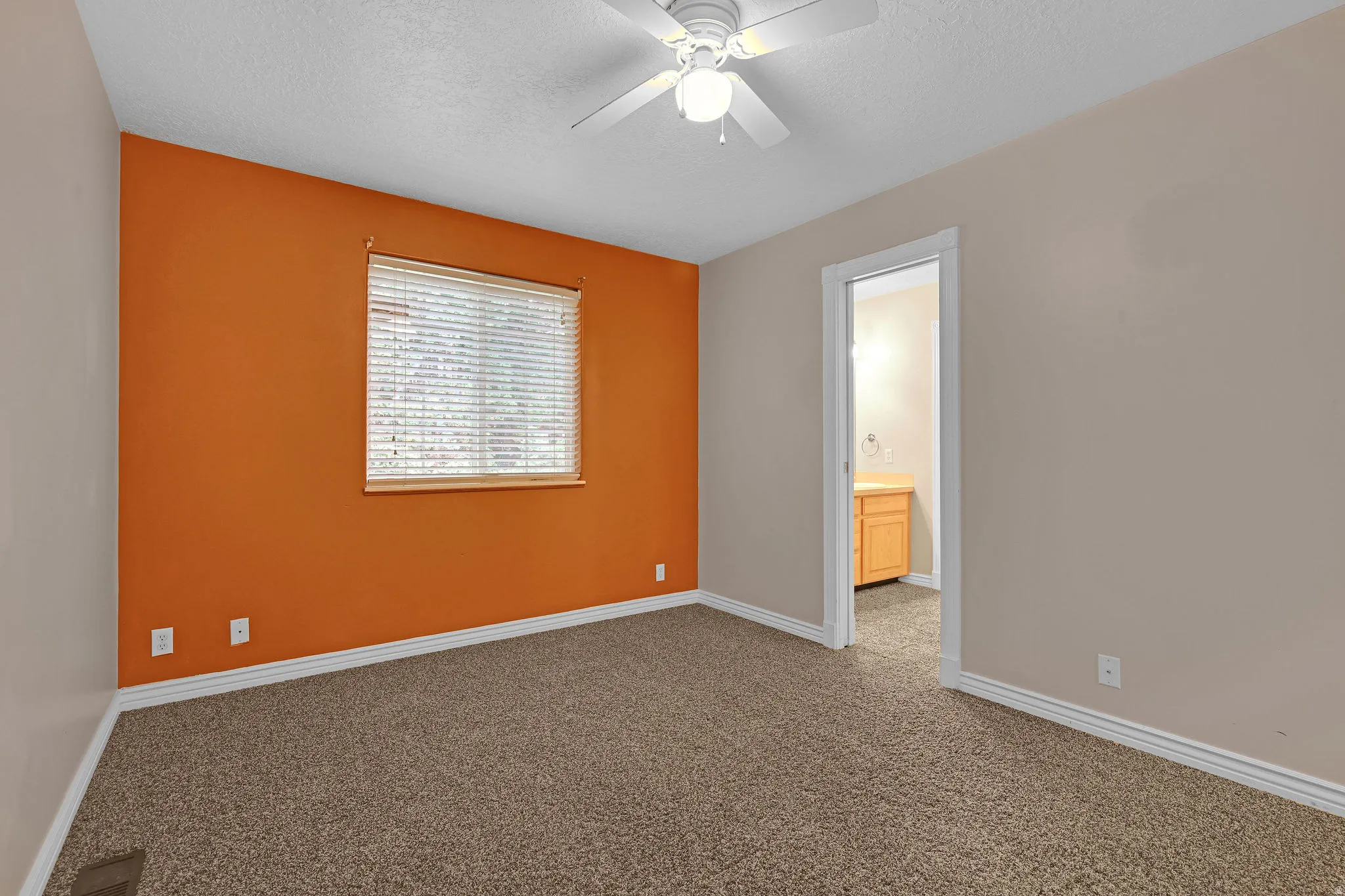 Carpeted empty room featuring a textured ceiling and ceiling fan