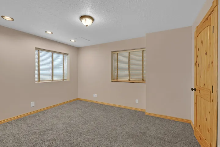 Carpeted empty room featuring a textured ceiling and recessed lighting
