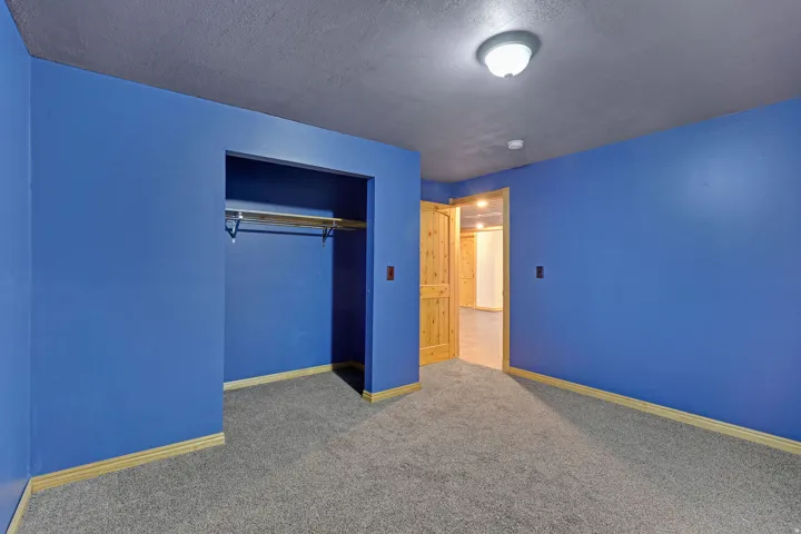 Unfurnished bedroom with a textured ceiling, carpet, and a closet