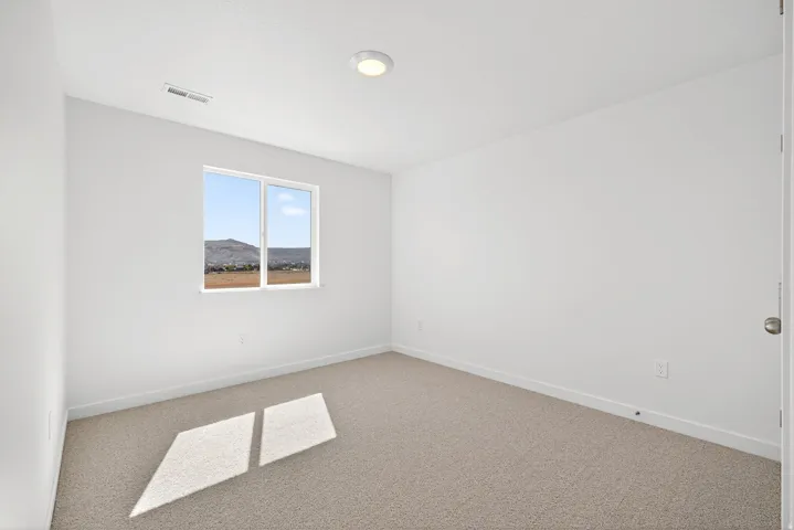 Carpeted empty room featuring baseboards
