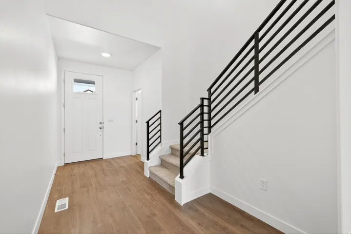 Entryway with stairs, wood finished floors, and recessed lighting