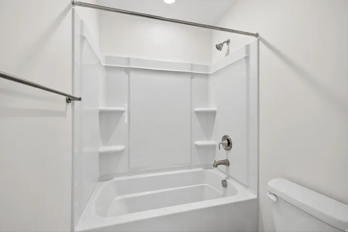 Full bath featuring toilet and shower / bath combination