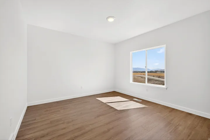 Unfurnished room with wood finished floors and a mountain view