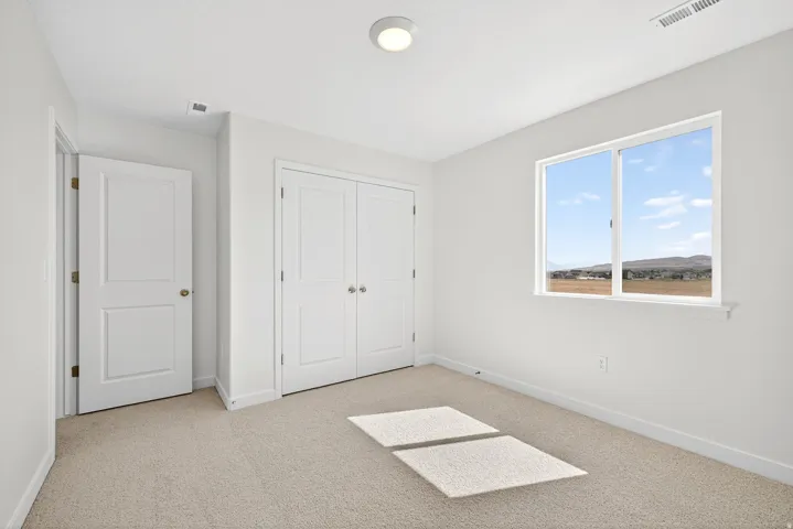 Unfurnished bedroom featuring light carpet and a closet