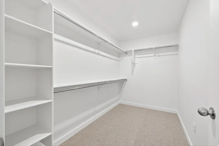 Walk in closet featuring light carpet