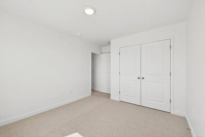Unfurnished bedroom with carpet and a closet
