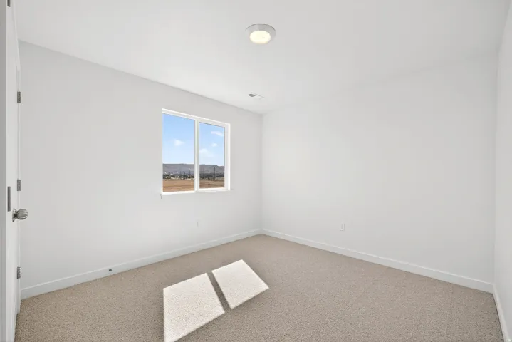 Carpeted spare room with baseboards