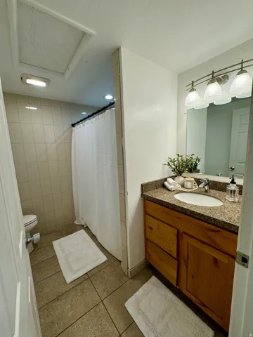 Bathroom featuring a shower with curtain, vanity, and light tile patterned flooring