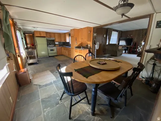 Dining room with wood walls and dark stone finish flooring