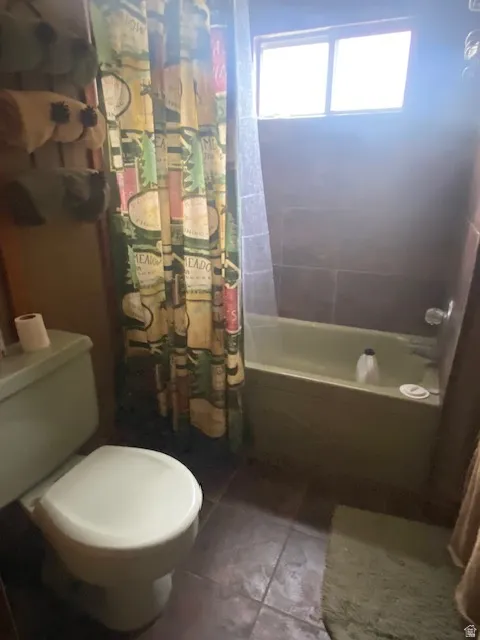 Bathroom with shower / bath combo with shower curtain and tile patterned floors