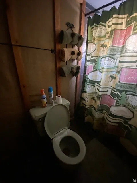 Full bath featuring curtained shower and toilet