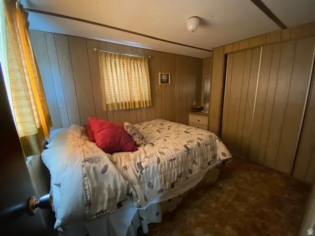 Carpeted bedroom with wooden walls