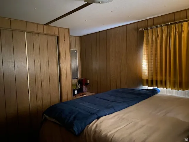 Bedroom with a closet and wooden walls