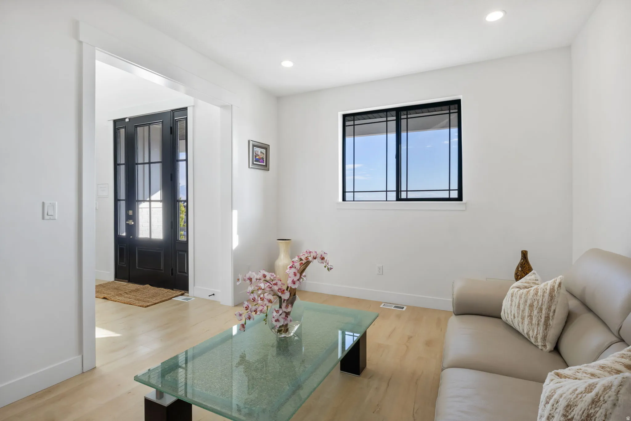 Living room with light wood-style floors and recessed lighting