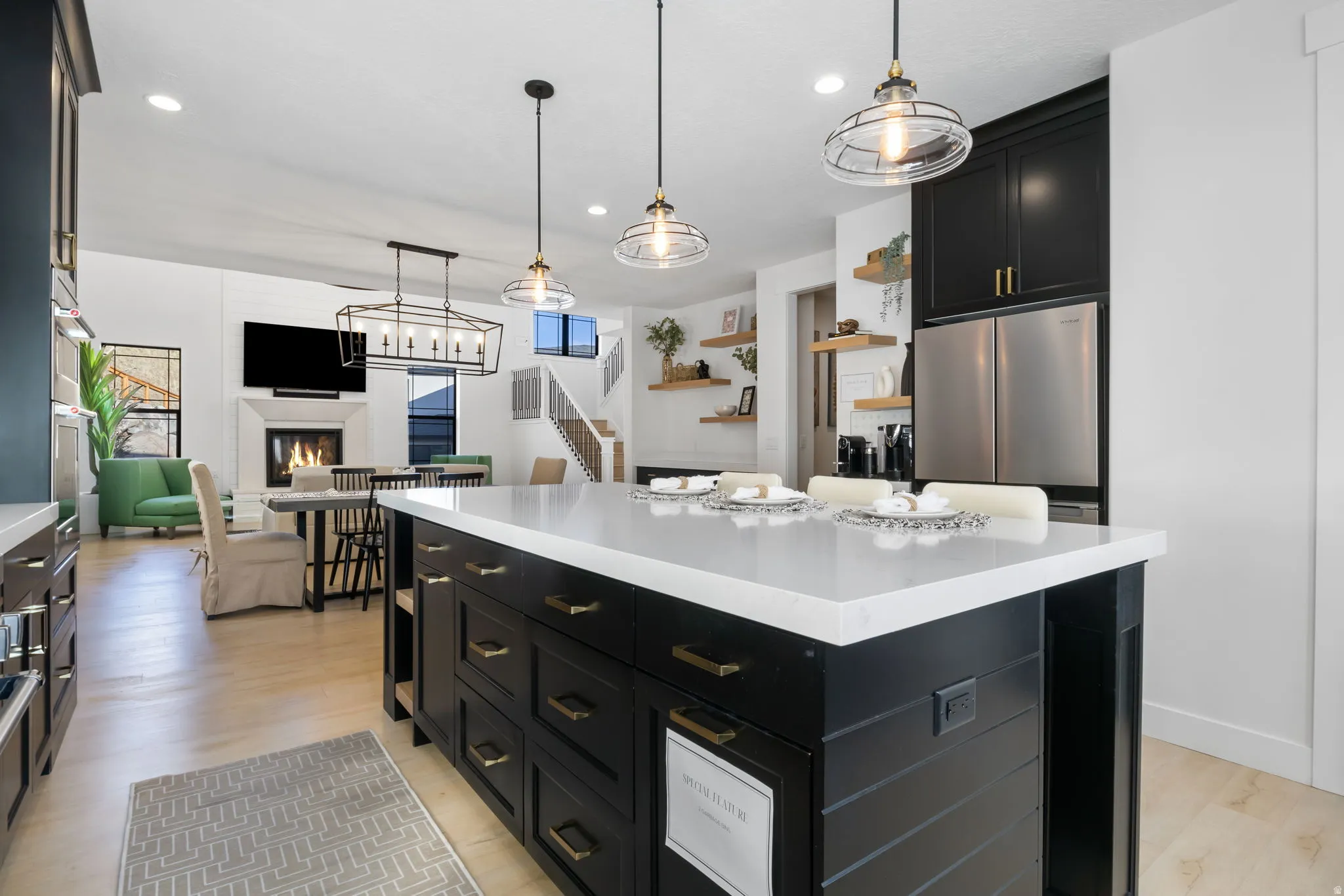 Kitchen with dark cabinetry, decorative light fixtures, a center island, freestanding refrigerator, and recessed lighting