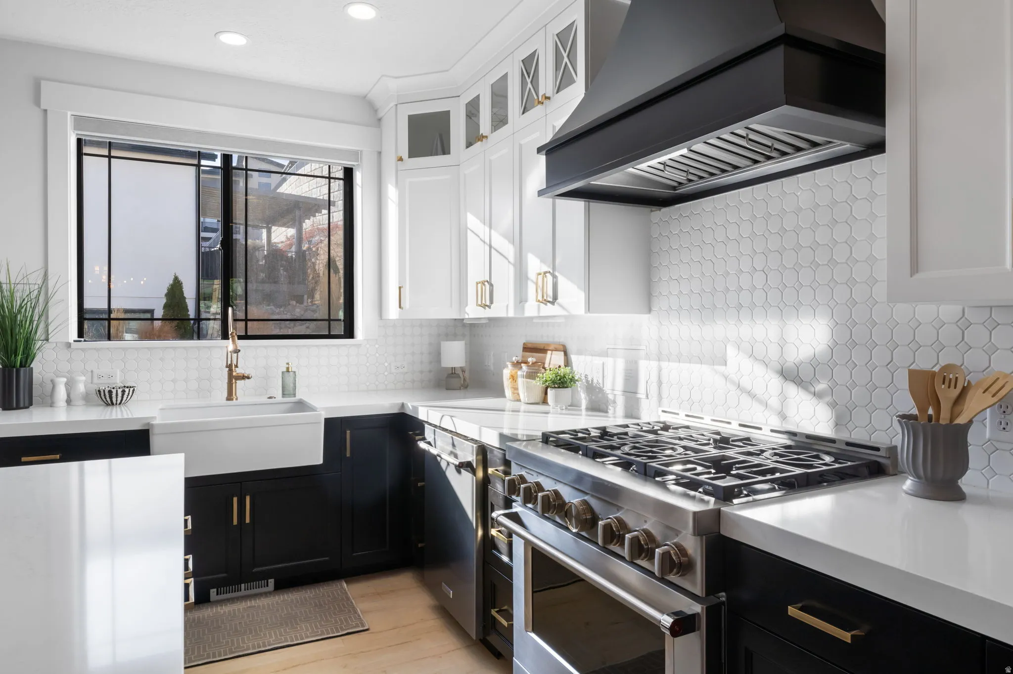 Kitchen featuring dark cabinetry, custom exhaust hood, stainless steel appliances, and white cabinetry