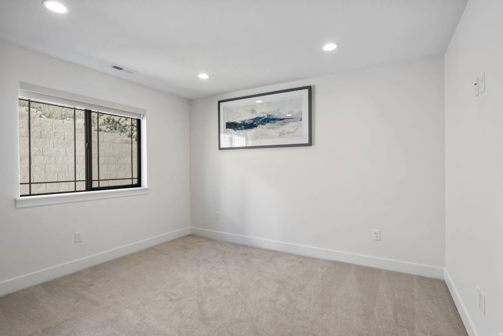 Empty room featuring light carpet and recessed lighting