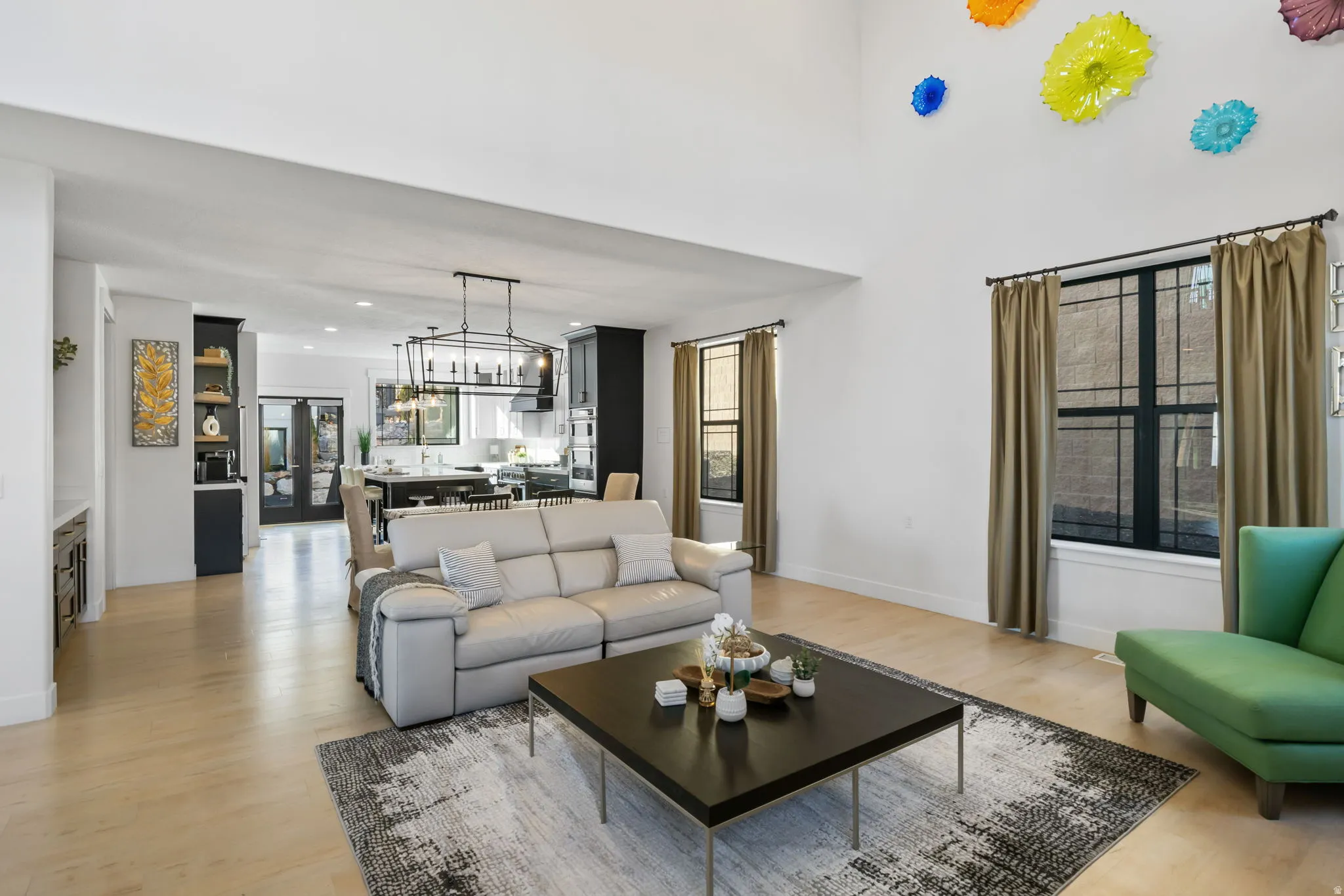 Living room with light wood-type flooring, french doors, and a chandelier