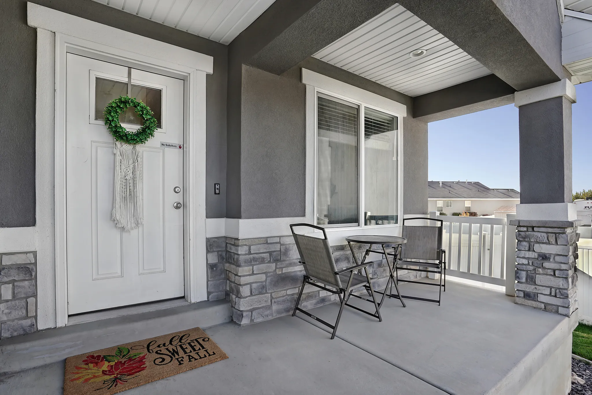 Property entrance with stone siding and stucco siding