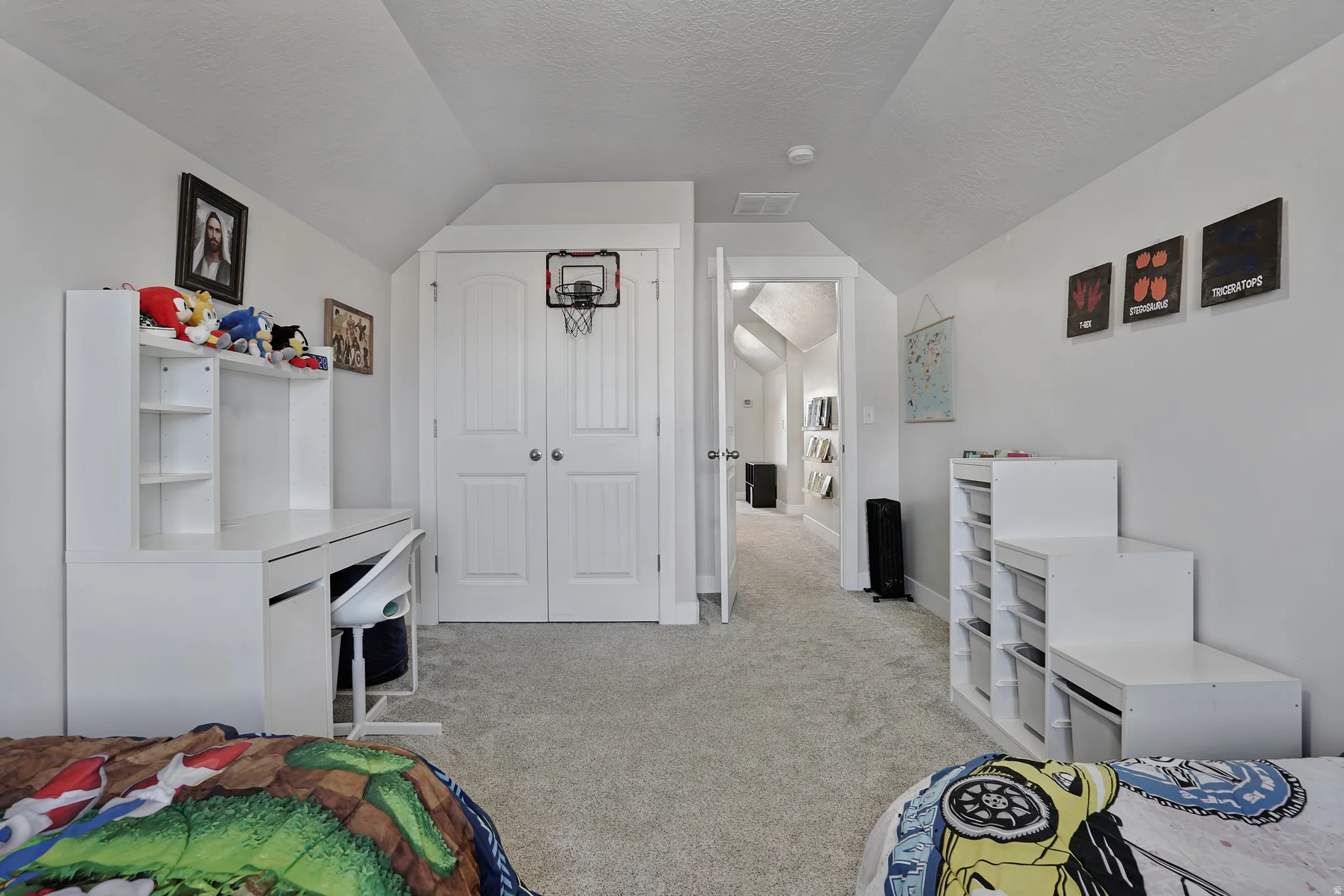 Bedroom with vaulted ceiling, light colored carpet, a textured ceiling, and a closet