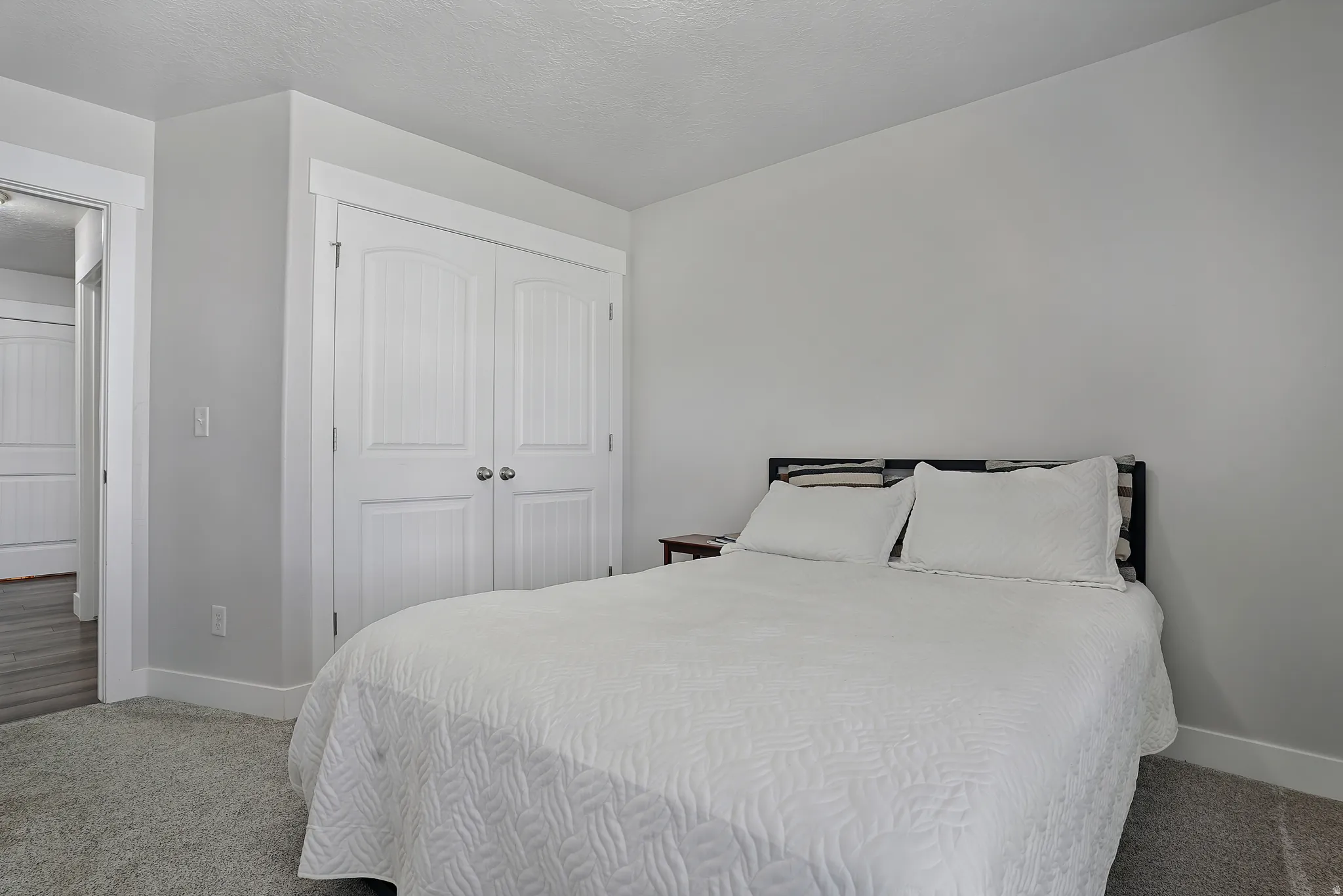Bedroom featuring carpet flooring, a closet, and a textured ceiling