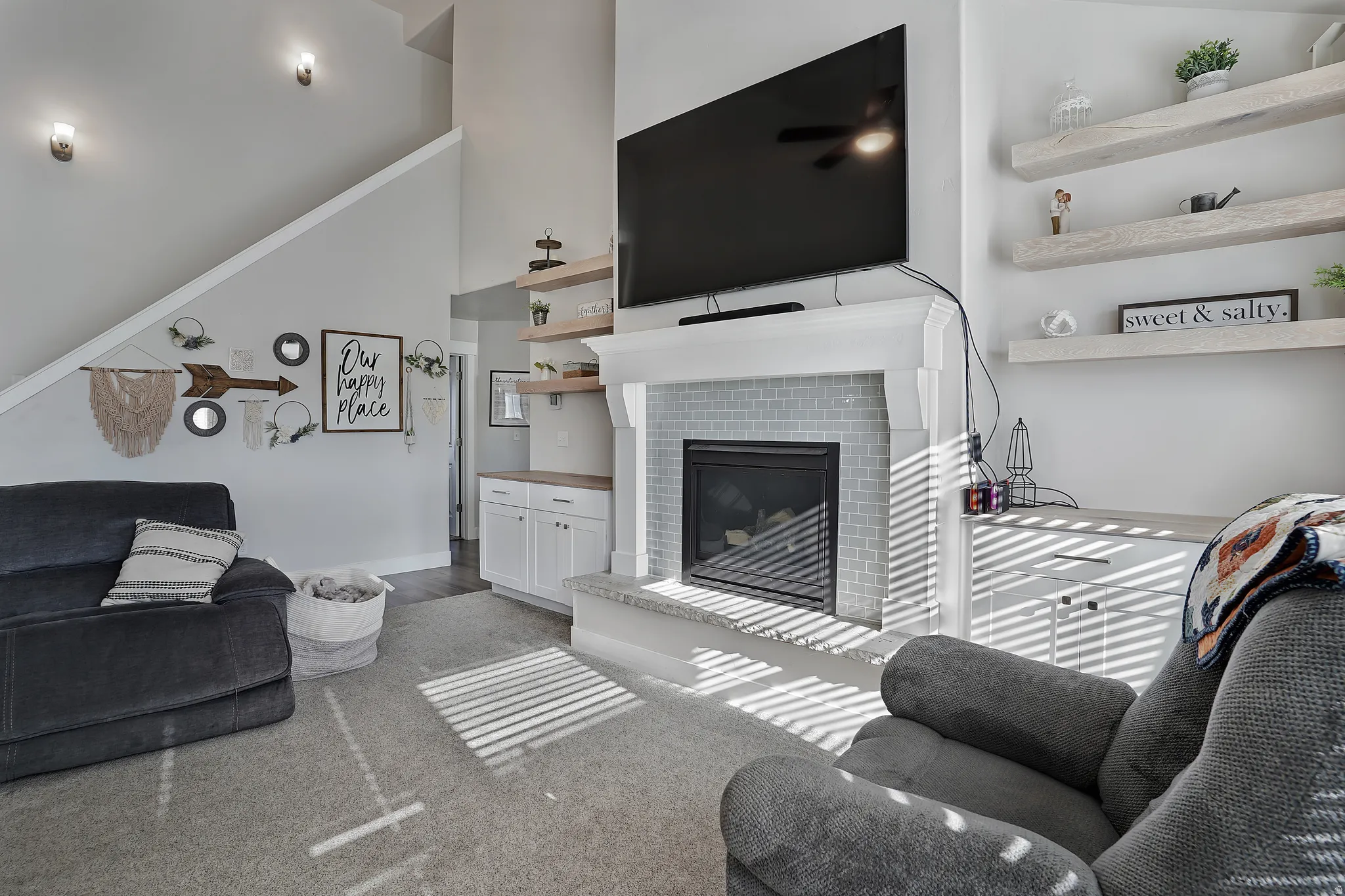 Living area featuring a tile fireplace and a high ceiling