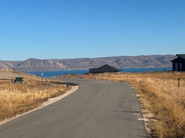 View of asphalt street featuring a water and mountain view