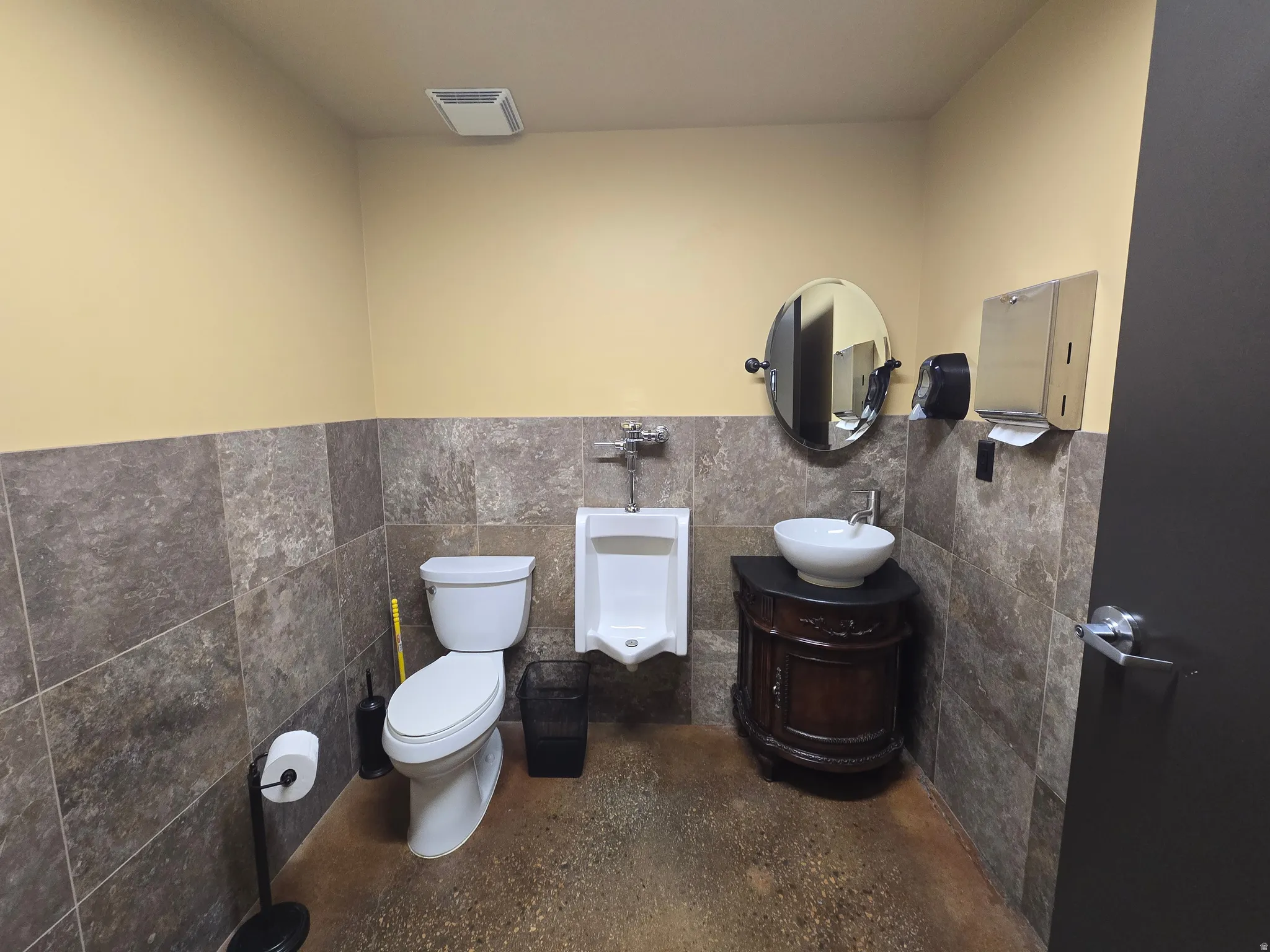 Half bathroom with tile walls, vanity, and a wainscoted wall