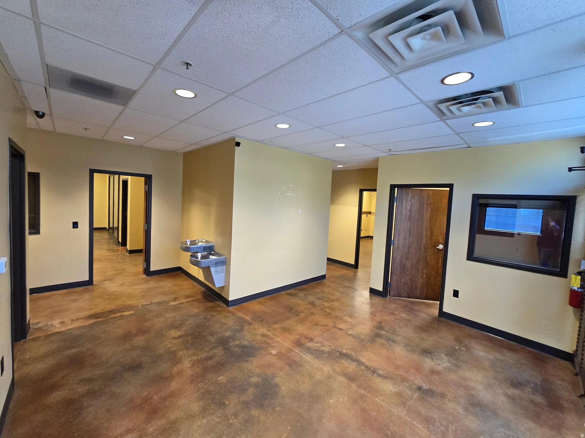 Unfurnished room featuring a drop ceiling, concrete flooring, and recessed lighting