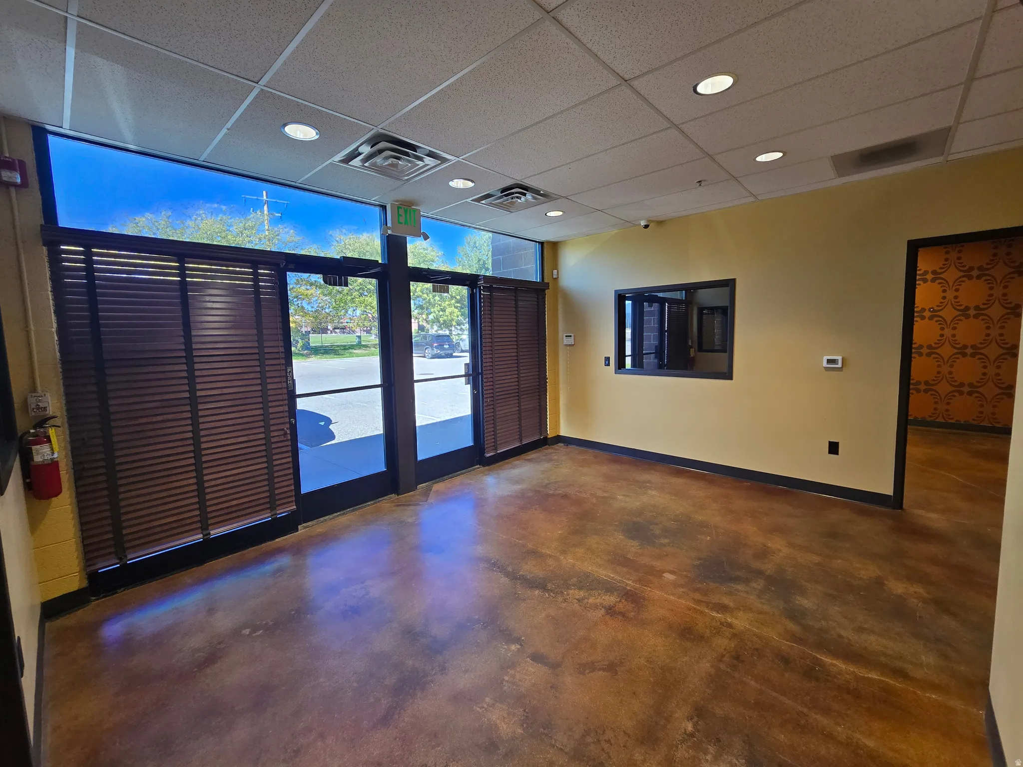 Unfurnished room with a drop ceiling, finished concrete flooring, and recessed lighting