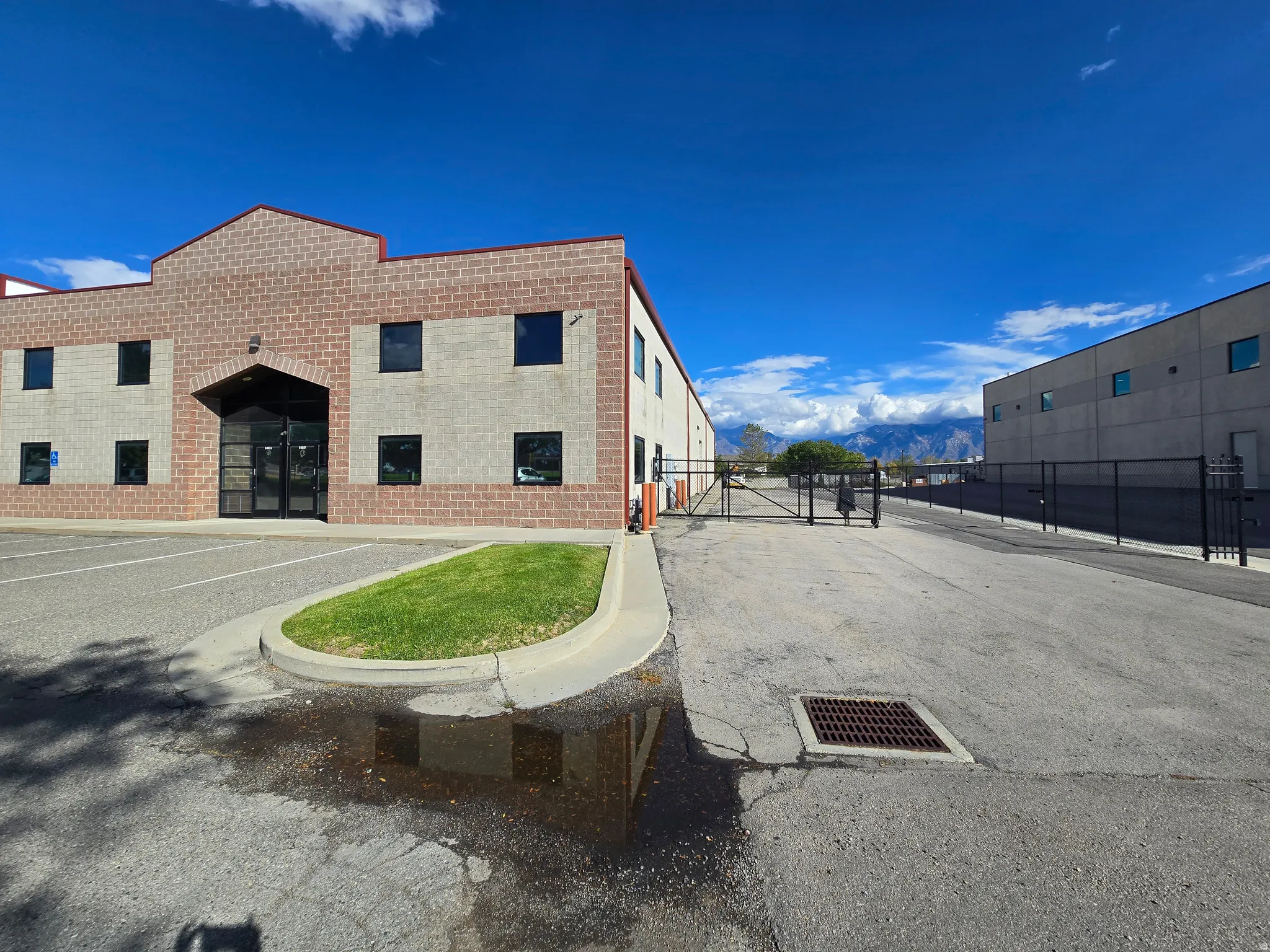 View of side of property with a gate, brick siding, and a mountain view