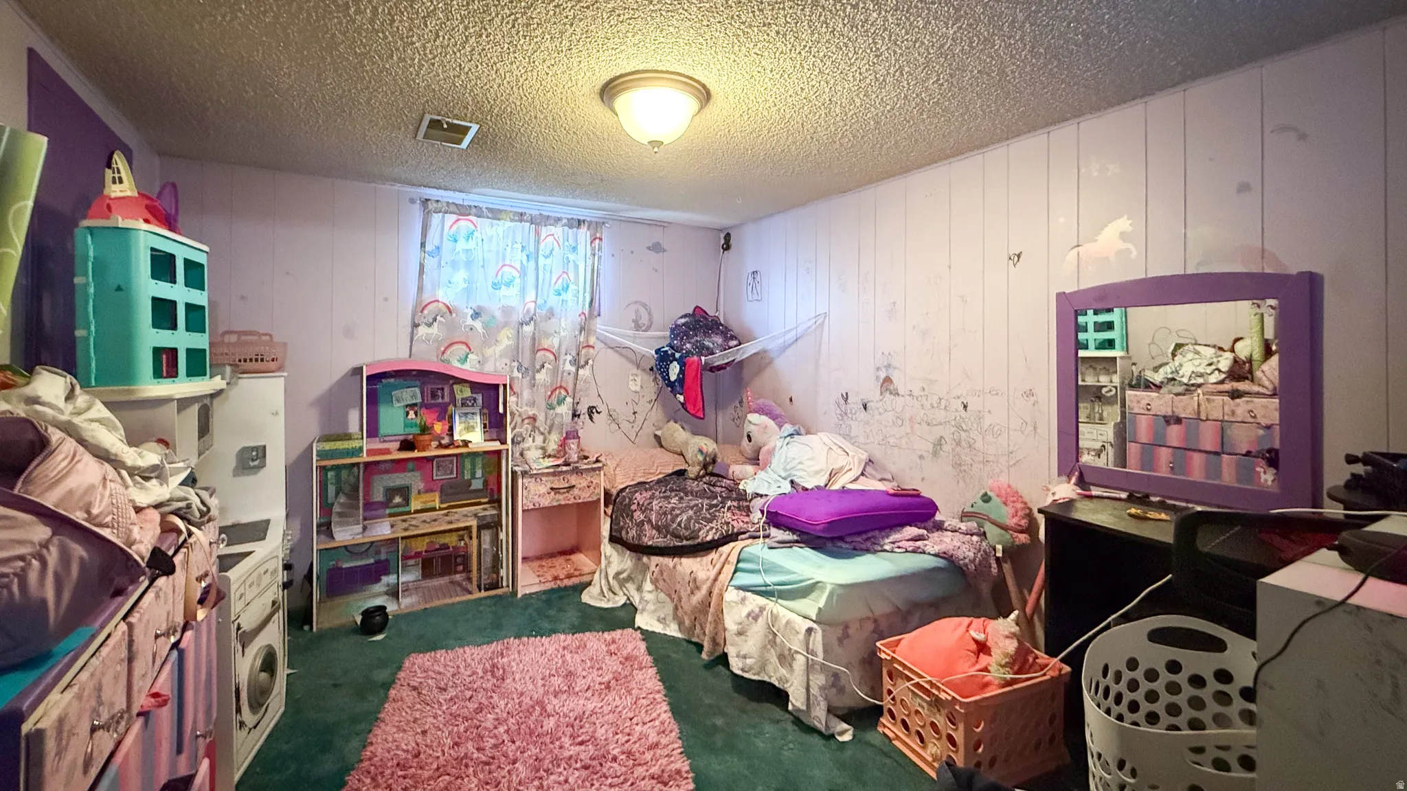 Bedroom with wood walls, a textured ceiling, and dark carpet