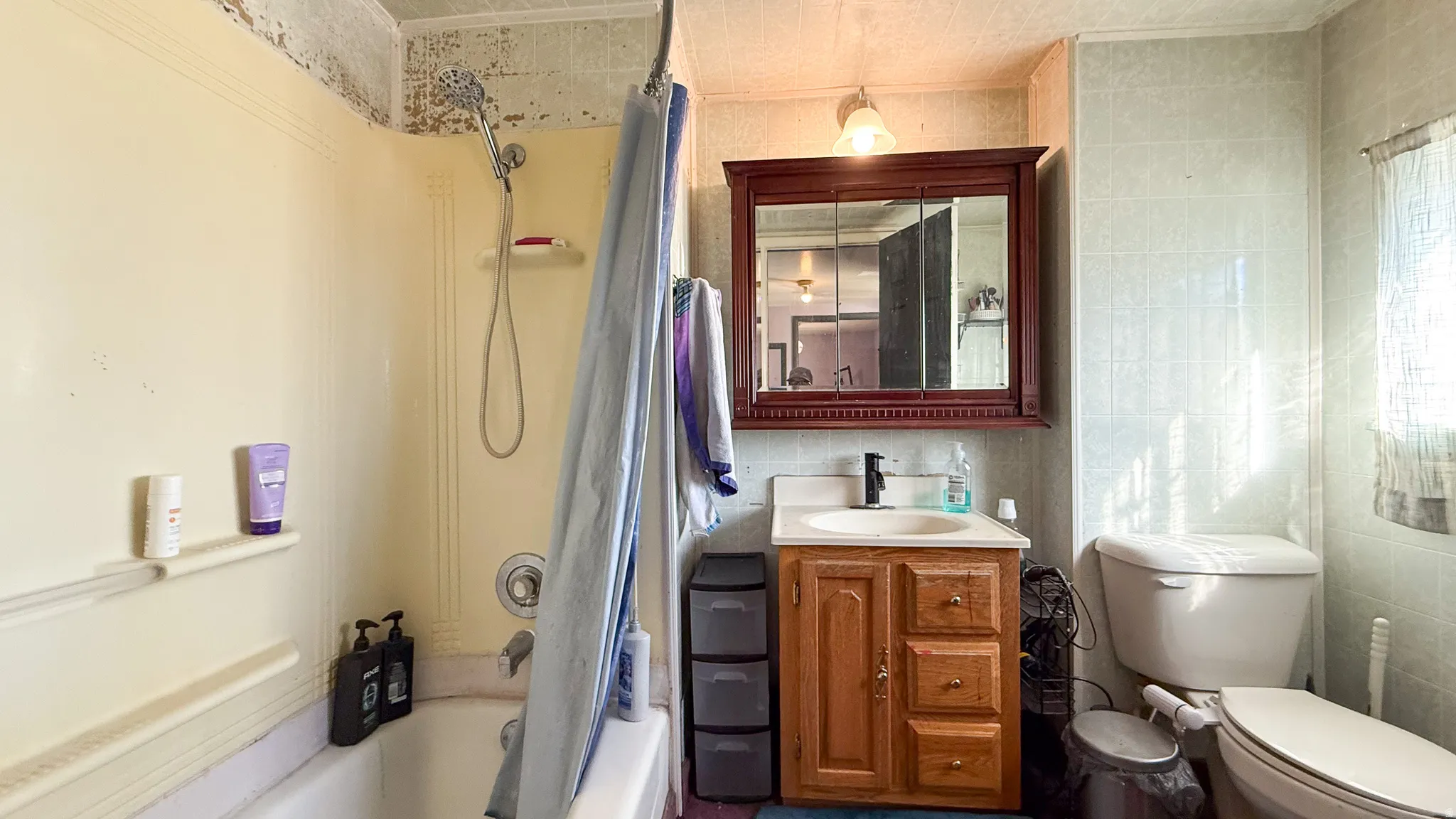Bathroom with shower / bathtub combination with curtain, tile walls, and vanity