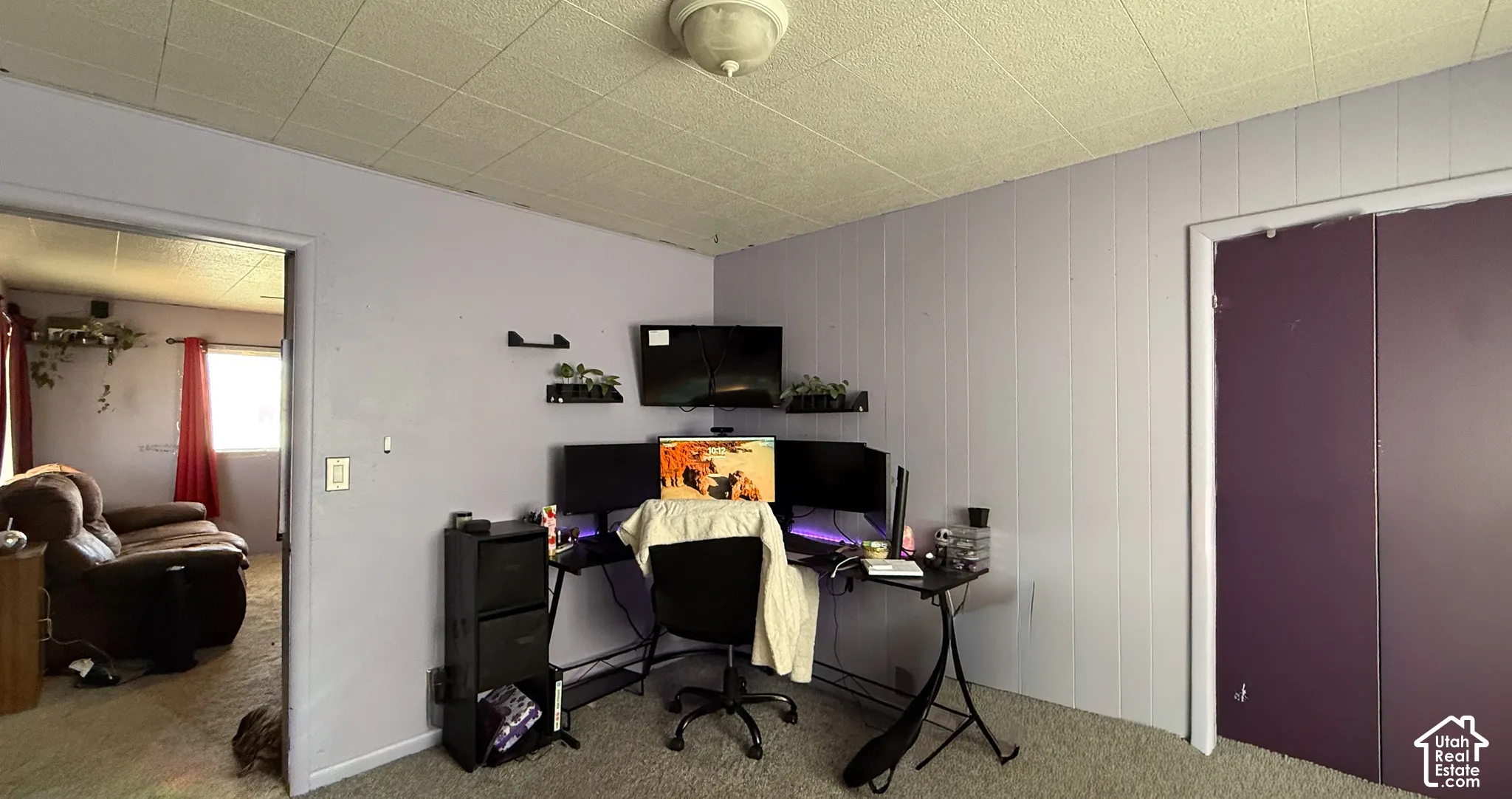 Office space with carpet and wood walls