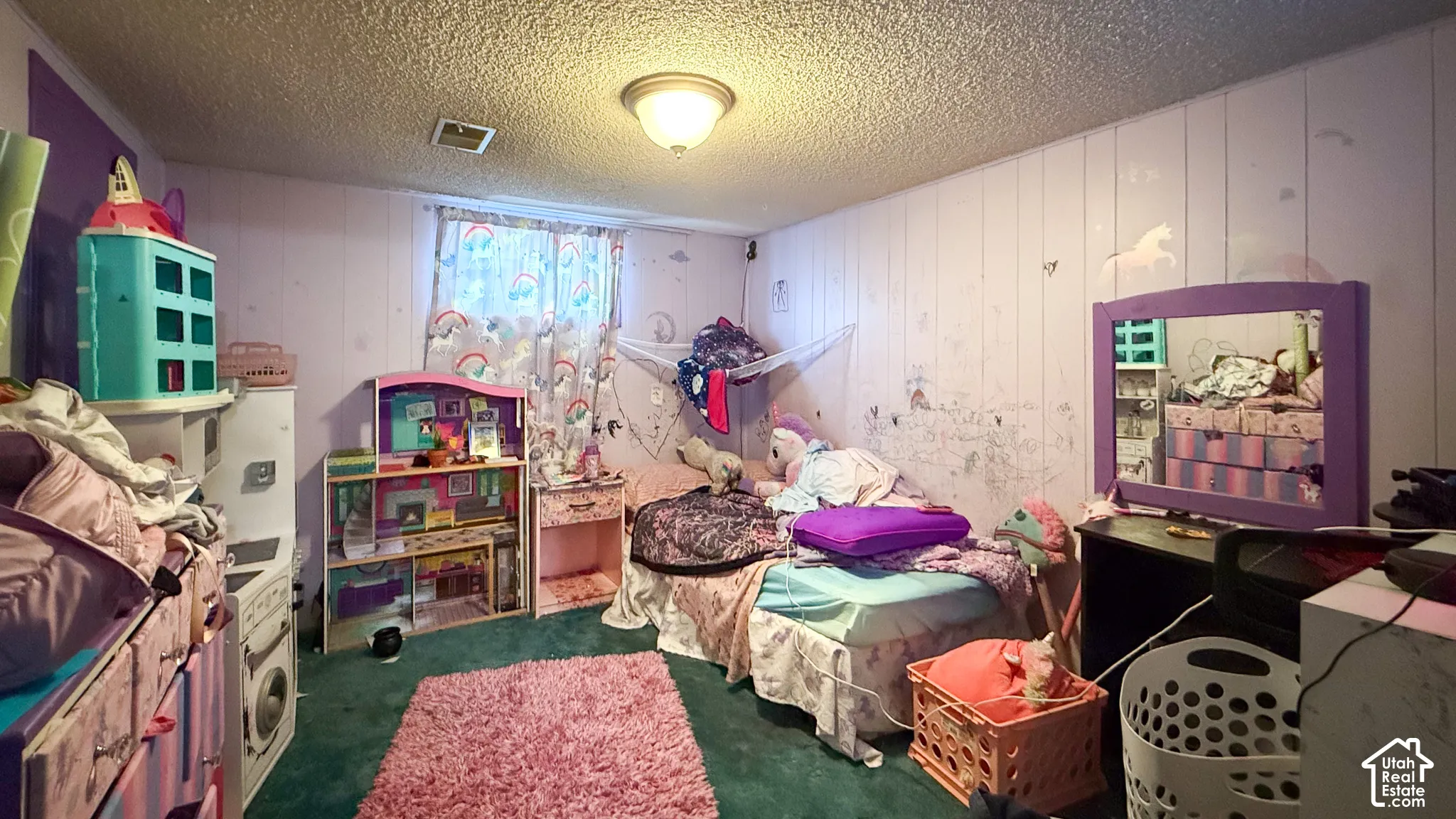 Bedroom with wood walls, a textured ceiling, and dark carpet