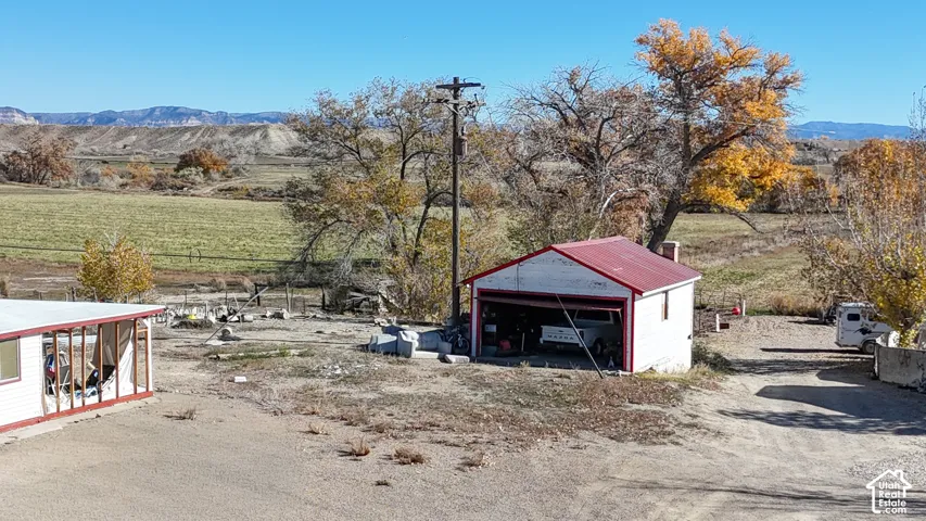 View of yard with an outbuilding, a mountain view, a view of countryside, and a detached garage