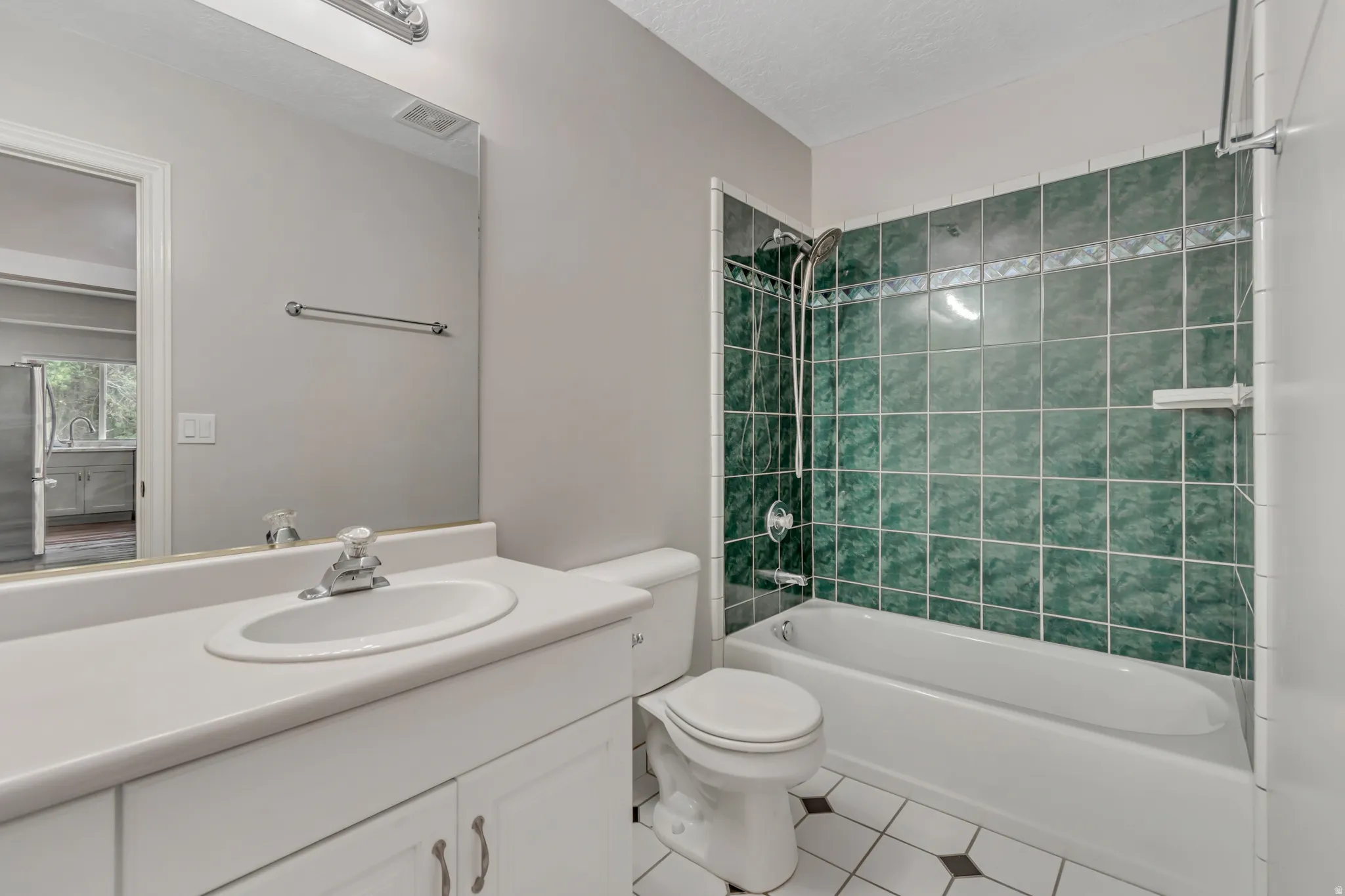Bathroom with  shower combination, tile patterned floors, vanity, and a textured ceiling