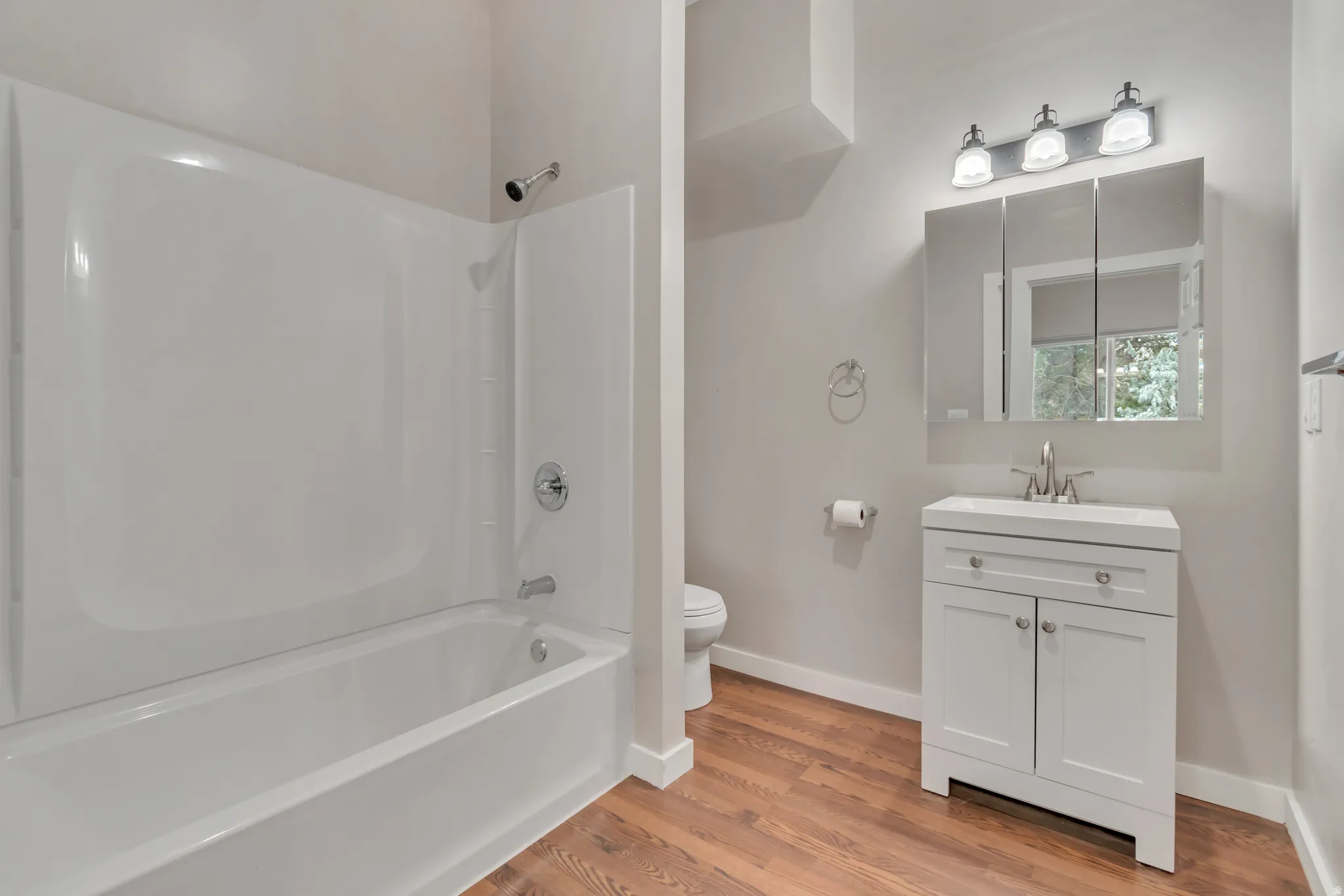 Bathroom featuring vanity, light wood-style flooring, and bathing tub / shower combination